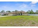 Spacious single-story home featuring a sprawling green lawn and well-maintained landscaping at 12026 Penguin Ave, Weeki Wachee, FL 34614