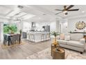 Open-concept living space featuring modern kitchen with island, dining area, and cozy living room with neutral decor and ample lighting at 12420 Talpa St, Spring Hill, FL 34608