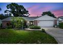 Charming single-story home with brick accents, lush landscaping, and a well-maintained front yard at 1265 Royal Oak Dr, Dunedin, FL 34698