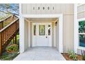 Close up of the white front door featuring decorative glass panels, accompanied by well maintained landscaping at 13901 Vacation Ln, Odessa, FL 33556