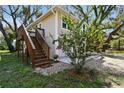 Charming two-story home featuring a light beige exterior, complemented by a landscaped yard and lush trees at 13901 Vacation Ln, Odessa, FL 33556