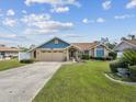 Charming single-Gathering home featuring well-maintained landscaping, a two-car garage, and a welcoming entrance at 14646 Coronado Dr, Spring Hill, FL 34609