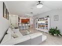 Bright living room with tile flooring, a comfortable sofa, and seamless flow into the kitchen and dining area at 18530 Dobson Dr, Hudson, FL 34667