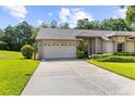 Lovely home showcasing a spacious driveway leading to a two-car garage, complemented by lush landscaping at 18736 Bent Pine Dr, Hudson, FL 34667