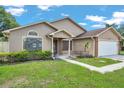 Well-maintained single Gathering home with lush green lawn and mature landscaping under a bright blue sky at 2048 Ground Squirrel Dr, New Port Richey, FL 34655