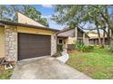 Inviting front exterior featuring a stone facade, garage, and landscaped walkway at 2101 Sunset Point Rd # 201, Clearwater, FL 33765