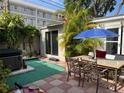 Backyard patio area with a hot tub, dining set, and tropical landscaping at 21045 Lazy Days Cir, Lutz, FL 33558