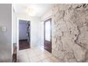 Inviting foyer with tile flooring, stone accent wall, and stylish front door at 22348 Olean Blvd, Port Charlotte, FL 33952