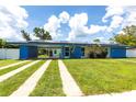 Charming blue house with solar panels, featuring a carport and well-maintained lawn at 22348 Olean Blvd, Port Charlotte, FL 33952