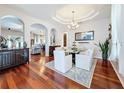 Elegant dining room with a modern chandelier, large mirror, and hardwood flooring at 2326 Mountain Ash Way, New Port Richey, FL 34655
