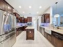 Bright kitchen with stainless steel appliances, a center island, and dark wood cabinetry at 2326 Mountain Ash Way, New Port Richey, FL 34655