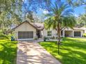 Charming single-story home featuring a well-manicured lawn, two-car garage and covered carport at 2342 Countryside Dr, Spring Hill, FL 34606