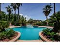 Backyard pool area featuring mature palm trees, lush vegetation, and a tranquil fountain at 2987 Wentworth Way, Tarpon Springs, FL 34688