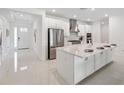 Modern kitchen with white cabinetry, stainless steel appliances, large kitchen island, and gas cooktop at 33466 Landsman Loop, Wesley Chapel, FL 33543
