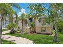 Inviting two-story home showcasing a well-maintained lawn, mature trees, and a classic architectural design at 4052 Marine Pkwy, New Port Richey, FL 34652