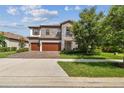Beautiful two-story home featuring stone accents, a three-car garage, and landscaped front yard at 4083 Woods Rider Loop, Odessa, FL 33556