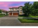 Charming two-story home with stone details, a three-car garage, and a lush front lawn at 4083 Woods Rider Loop, Odessa, FL 33556
