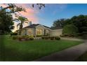 Charming single-story home featuring manicured landscaping at dusk with a spacious driveway at 4351 Mallard Lake Dr, Spring Hill, FL 34609