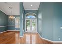 Elegant foyer with hardwood floors, an arched doorway, and a view of the front yard through glass doors at 4351 Mallard Lake Dr, Spring Hill, FL 34609