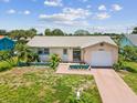 Charming single-story home featuring a one-car garage, tropical landscaping and lovely curb appeal at 4567 Great Lakes S Dr, Clearwater, FL 33762