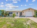 Charming single-story home featuring a one-car garage, tropical landscaping and lovely curb appeal at 4567 Great Lakes S Dr, Clearwater, FL 33762