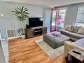 Cozy living room featuring hardwood floors, neutral-colored furniture, and bright natural light at 4628 Irene Loop, New Port Richey, FL 34652