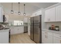 Modern kitchen featuring stainless steel appliances, white cabinets, and stylish pendant lighting at 4752 Weasel Dr, New Port Richey, FL 34653