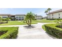 Lush green lawns, mature palm trees, and a winding walkway offer a serene community setting at 4754 Marine Pkwy # 103, New Port Richey, FL 34652