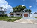Adorable single story home with white picket fence, mature shade trees, and an inviting exterior at 4853 Alcea St, New Port Richey, FL 34652