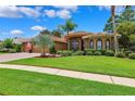 Stunning home featuring mature landscaping, elegant architectural details, and a well-manicured lawn at 5121 Delacroix Dr, Brooksville, FL 34604
