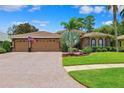 Charming home featuring a paved driveway leading to a two-car garage and lush landscaping at 5121 Delacroix Dr, Brooksville, FL 34604