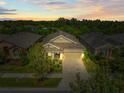Twilight aerial view of a well-maintained single story home with lush backyard and inviting curb appeal at 6130 Colmar Pl, Apollo Beach, FL 33572