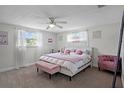 Bedroom with windows allowing natural light, a ceiling fan and decorative furnishings at 6144 Glenwood Dr, New Port Richey, FL 34653