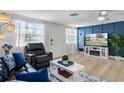 Cozy living room featuring a stylish blue accent wall, a fireplace, and modern decor at 6144 Glenwood Dr, New Port Richey, FL 34653