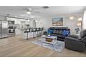 Bright living room featuring modern kitchen, island seating, and a cozy seating area with leather furniture at 6144 Glenwood Dr, New Port Richey, FL 34653