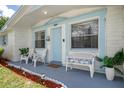 Inviting front porch with comfortable seating and light blue trim, creating a cozy and welcoming entrance at 6144 Glenwood Dr, New Port Richey, FL 34653