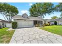 Inviting single-story home with dormer windows, a two-car garage and decorative driveway at 6282 Darien Way, Spring Hill, FL 34606