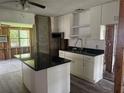 Kitchen area showcasing updated white cabinets and modern black countertops at 6826 Driftwood Dr, Hudson, FL 34667