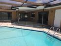 Exterior view of the screened pool, patio, and fenced in yard with access to the house at 6932 Pin Cherry Ln, Port Richey, FL 34668