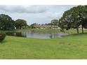 Scenic pond with fountain feature and lush green lawn, providing a tranquil and picturesque setting in the community at 7614 Radcliffe Cir # B213, Port Richey, FL 34668
