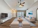 Staged living room featuring vaulted ceilings, wood-look floors, and comfortable furnishings at 10124 Heathcliff St, Spring Hill, FL 34608