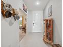 Inviting home entryway featuring tile flooring, decor, and a view into the living area at 1098 Old Windsor Way, Spring Hill, FL 34609