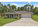 Well-maintained single-story home with a two-car garage, long driveway, and attractive landscaping at 11034 Flock Ave, Weeki Wachee, FL 34613