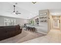 Open-concept living room features a vaulted ceiling, ceiling fan, and breakfast bar connecting to the kitchen at 11034 Flock Ave, Weeki Wachee, FL 34613