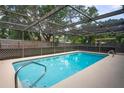 Screened-in pool area featuring a sparkling blue pool and a spacious deck for relaxing or entertaining at 1131 Bentley Ave, Spring Hill, FL 34608