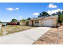 Street view of a single-story home featuring an attached garage and long concrete driveway at 11524 Meadow Dr, Port Richey, FL 34668