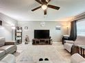 Open living room featuring a ceiling fan, neutral color scheme, wood floors, and comfortable seating arrangement at 11722 Carissa Ln # 49A, New Port Richey, FL 34654