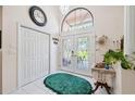 Bright foyer featuring tile flooring, a decorative chandelier, and an arched transom window above the front door at 12295 Clarendon Ct, Spring Hill, FL 34609