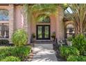 Charming entrance with double doors, mature landscaping, and decorative accents creating an inviting entryway at 12295 Clarendon Ct, Spring Hill, FL 34609