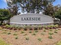 Entrance to the Lakeside community with stone and concrete sign amidst mulch and greenery at 14000 Lugano Ct, Hudson, FL 34669